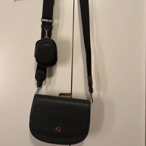 Svart DKNY väska - HELT NY svart väska frän DKNY som är köpt i märkesbutik utomlands. Nypris ca 3200kr. Kvitto finns!