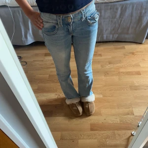 Ljusblå bootcut jeans Gina Tricot 152 - Snygga ljusblå jeans från Gina Tricot i storlek 152. Inte super andvända. Materialet är mjukt denim i bomull. Jag på bilden är 155 cm lång jag tycker att dem är lite korta men dem passar ganska bra.