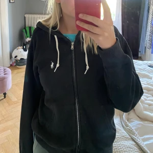 Ralph louren hoodie  - En svart ralph louren hoodie köpt för några årsedan. Den svarta färgen på hoodien har under tiden blivit en aning ljusare. Men annars väldigt bra i skick. Väldigt mysigt material att ha på sig.