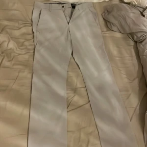 Ljusgrå golfbyxor  från Galvin Green nypris 1300 (oanvända) - Snygga ljusgrå kostymbyxor/ golfbyxor från Galvin Green med raka ben och klassisk passform. Byxorna har två framfickor, två bakfickor och bälteshällor. Materialet är mjukt och lätt, perfekt för en stilren look. Diskret broderad logga på bakfickan.