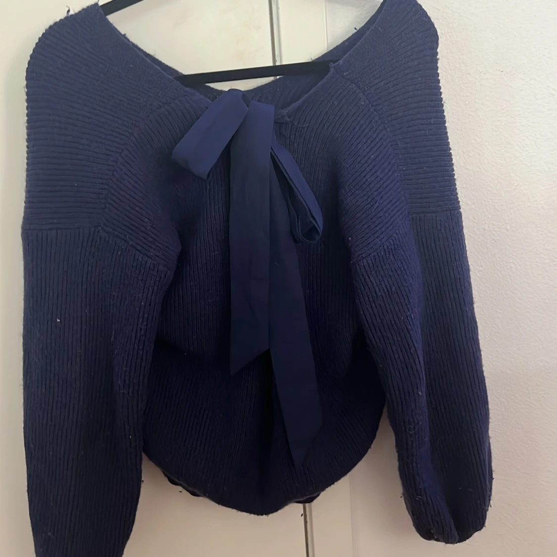 Mörkblå stickad tröja med rosett