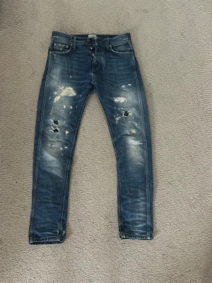 Blå slitna jeans från Jack & Jones - Säljer ett par blå jeans från Jack & Jones med slitningar. Vet inte vkn storlek de är då de it står men de är för små för mig att ha på mig o ta bilder med på. Mått finns på sista bilden