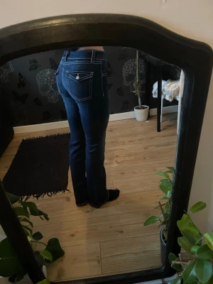 Mörkblå bootcut jeans Gina Tricot - Säljer ett par mörkblå jeans från Gina Tricot i storlek 170. Jeansen har bootcut-modell, markerade vita sömmar och klassiska fickor både fram och bak. Materialet är jeans med stretch och passformen är normal. Perfekta till en avslappnad look.