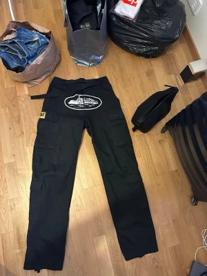 Corteiz Guerillaz Cargo - Svarta Corteiz Cargo. Använda men fortfarande i bra skick. Nypris 3500kr. Kvitto finns även stockx tag bild 3.