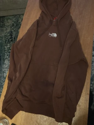 Brunn north face hoodie - En brun north face hoodie. Är storlek M , men passar även på S . Den är lite använd och har bortriven text på visa ställen. Men är fortfarnadd hyfsat bra kvalitet på . 