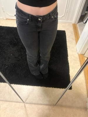 Bootcut jeans från 157 i svart, S - Jag säljer ett par gråa bootcut jeans från 157 i storlek S. Fickorna har silvriga knappar och modellen har låg midja. Jeansen är i stretchiga och sitter riktigt bra. Perfekta till sneakers eller boots.