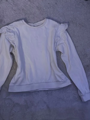 Vit Sweatshirt  - En bekväm tröja som passar både i vardagen och när man vill va extra finklädd eftersom att den är basic med lite volanger. Materialet är som på en hoodie🩷