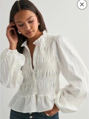 Vit blus  - Säljer denna super snygga blus från Nelly som jag fått dubblett av. Den är helt ny med lapp❤️