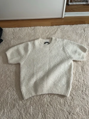 Vit stickad tröja från Gina Tricot - Mysig vit stickad tröja från Gina Tricot i storlek S. Tröjan har rund halsringning och ribbade muddar. Super fin nu till våren.
