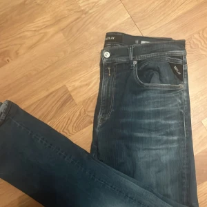Replay mörkblå jeansbyxor slim - Snygga mörkblå jeans från Replay med klassisk femficksdesign och diskreta slitningar framtill. Jeansen har en slim passform och är tillverkade i mjukt jeansmaterial som sitter skönt. Perfekta för dig som gillar stilrena och moderna jeans. Original pris 1300 