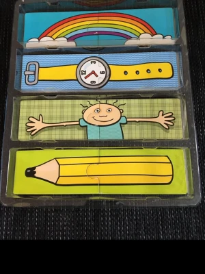 Barnleksaker  - Olika färgglada pusselbitar med motiv som regnbåge, klocka, frukt, julgran, orm och krokodil.