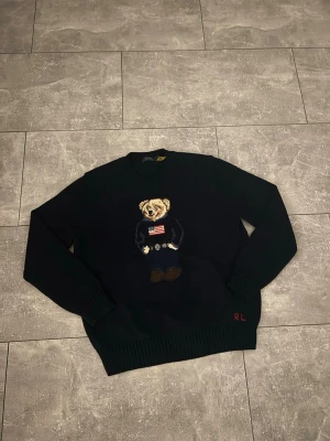 Ralph Lauren sweater - Hej, vi säljer nu denna eleganta och stiliga Ralph lauren polo sweatern med polo’s klassiska björn på. Den passar perfekt för vardagligt bruk och för  stiliga tillfällen! Hör av er vid frågor.