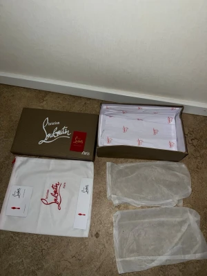 Svarta sneakers från Christian Louboutin - Säljer ett par svarta sneakers från Christian Louboutin i mocka med klassisk röd sula och svarta snören. Skorna har en stilren och clean design med rund tå och platt sula. Kommer med originalkartong, dustbags och papper. Priset kan diskuteras