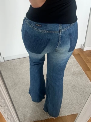 Blå bootcut jeans med rå kant - Snygga blå Freesoul label jeans i storlek 28. Jag är 158cm. Knappen är ditsydd samt att kanten nedtill tror jag blivit avklippt utav förra ägaren, se bild. Svag bootcut <3