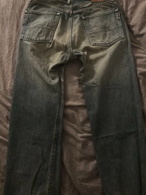 Edwin Selvedge jeans - Säljer ett par klassiska Edwin Selvedge jeans i mörkblå tvätt med slitningar och hål på vänster ben. Jeansen har raka ben, fem fickor och den ikoniska röda selvedge-sömmen. Materialet är robust denim i bomull och passformen är baggy. Pris går såklart att diskuteras