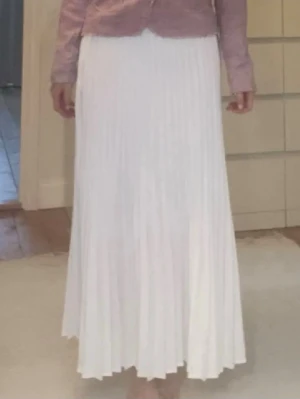 Långkjol - Lång veckad kjol. Dragkedja på sidan av midjan för att kunna sätta på sig den smidigare