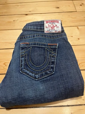 True religion - low waist - made in Usa - Ett par superfina True religion i straight och lågmidjade. De är i toppskick utan slitningar eller liknande. Modellen är varken skinny eller bootcut utan normal fit  De är uppsydda på ett väldigt snyggt sätt.  Mått:   Ytterbenslängd: 93 cm  Innerbenslängd: 74 cm  Midja: 36 cm  Bara höra av dig om du undrar någonting om bilder eller mått så fixar med en gång.  📦 Skickar inom 24 h, ofta snabbare.