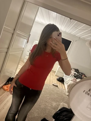 Röd tight t-shirt - Säljer en enkel och stilren röd t-shirt med tight passform. T-shirten är kortärmad och gjord i mjuk bomull, perfekt till jeans eller kjol. Klassisk rund halsringning och utan tryck eller mönster.