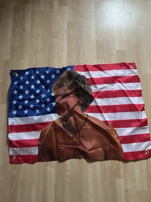 JJ MAYBANK USA FLAGGA - En amerikans flagga med JJ maybank motiv från outer banks. Lite ostruken på bilden men kan absolut fixas vid köp!😋