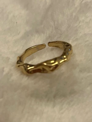 Guldfärgad ring ✨ vågig & modern design - Trendig guldfärgad ring med vågig/organisk form som ger ett mjukt men stilrent uttryck ✨ Minimalistisk men med det lilla extra – superfin ensam eller tillsammans med andra ringar. ✨ Modern & trendig ✨ Vågig, unik design ✨ Lätt att matcha – perfekt till vardag & fest I mycket fint skick 🤍 Skickas snabbt 📦 Skriv gärna vid frågor eller om du vill ha fler bilder!