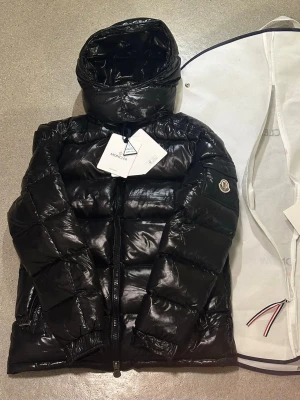 Moncler Maya Size 2 - Moncler Maya down jacket 🖤 Only worn a few times – excellent condition, no flaws 100% authentic luxury puffer with premium down filling Extremely warm yet lightweight, perfect for cold weather Iconic glossy Moncler design that holds its value Easy to style with streetwear or clean outfits Well cared for, stored properly in a smoke-free home Fast shipping / open to reasonable offers Message me for more pics or details ❄️ First come, first servedMoncler Maya down jacket 🖤 Only worn a few times – ex