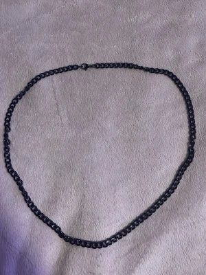 Svart kedje halsband - Säljer en enkel svart kedja som passar perfekt som accessoar. Kedjan är 50cm. Kedjan har klassiska länkar och ett smidigt lås. Stilren och lätt att matcha med olika looks.