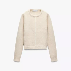 Stickad tröja  - Snygg beige stickad tröja från Zara med rund halsringning och lång ärm. Tröjan har en clean look med en tunn vit linje som detalj framtill och baktill. Perfekt för lager-på-lager och passar till allt från jeans till kjol. Storlek L men väldigt liten!! 