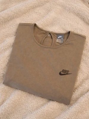 Beige Nike t-shirt  - Snygg beige t-shirt från Nike. T-shirten är helt ny, endast provad. Storlek XL i barnstorlek = S/M vuxen storlek 🤍