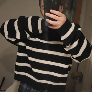 Svartvit randig stickad tröja - Säljer en oversized stickad tröja med breda svarta och vita ränder. Tröjan har lång ärm och är riktigt mjuk och skön. Den är lite som en magtröja och är anledningen till att jag vill sälja den. Jag bär S/M och detta är en M. Använd 8 gånger kankse. 60% cotton. 