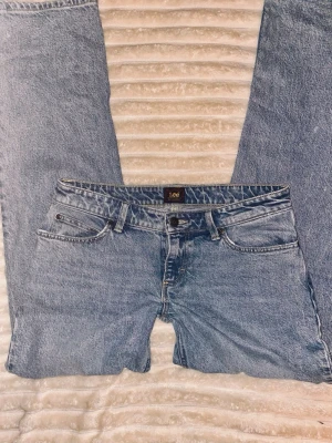 Lågmidjade jeans - Ett par snygga Lee jeans som är lågmidjade 😍de har en lite vintage stil i materialet som i sig är en snygg detalj✨ de har en rak stil i benen. W26 L33 (skulle säga S/M)                       Midjemått rakt över: 41cm. Innerbenslängd: 80cm