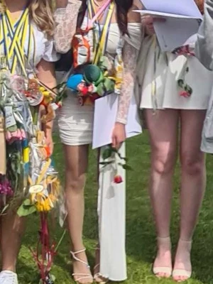 Vit offshoulder klänning med spetsärm - Säljer en vit kortklänning med offshoulder-design och långa spetsärmar. Klänningen har en unik detalj med en asymmetrisk slöja på ena sidan och smickrande tight passform. Perfekt för dig som vill sticka ut på student eller sommarfest! Använd bara en gång.