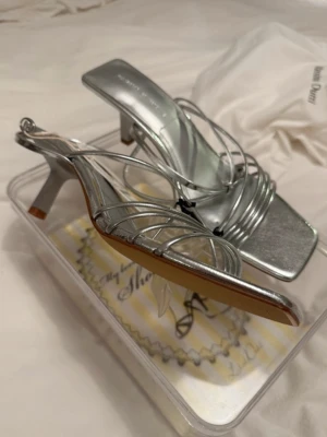 Silvriga klackskor - Silvriga klackskor!!🪩 Så fina och helt oanvända, finns lite få märken på sulan från att ha legat undan packade. Inget som syns när man har på sig dom förstås. Storlek 40 men passar även 39 och 41 eftersom de går att spänna åt/lossa dem lite.