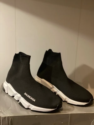 Balenciaga  - Säljer ett par Balenciaga Speed Trainer sneakers i svart med vit och svart chunky sula. Skorna har en strumpliknande ovandel i stretchig stickad textil och Balenciaga-logga på sidan. Superlätta och flexibla med modern design och rund tå.