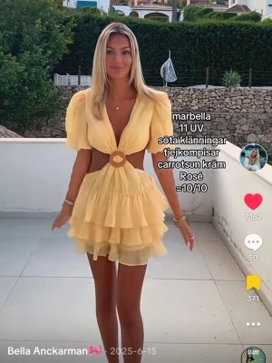 Gul volangklänning med cut out - SLUTSÅLD Supersöt kort gul klänning med puffärmar, djup v-ringning och cut out-detalj i midjan med rund spänne framtill. Kjolen har flera lager volanger som ger en flowy känsla. Perfekt för varma dagar!💛