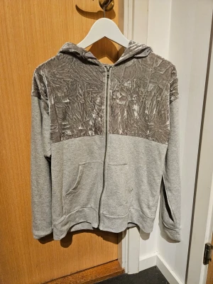 Zip hoodie  - Zip hoodie med halva tröjan med annat glansigt material. 