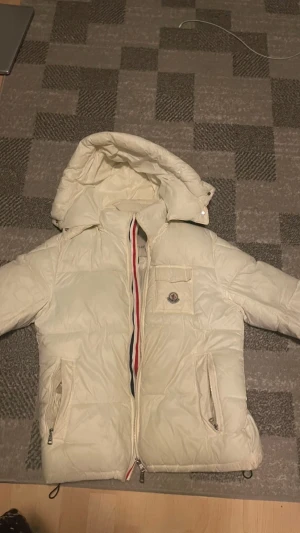 Vit Moncler jacka - Säljer en vit moncler jacka de är fortfarande i bra skick men anledning t varför jag säljer den är för jag växt ur den jackan är äkta och det finns digitalt kvitto på den letar efter snabba affärer därför säljer jag den för 1500kr 👍 
