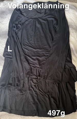 Svart volangklänning - Svart långärmad klänning med volangdetaljer. Klänningen har en avslappnad passform och är perfekt för dig som gillar en enkel men ändå trendig look. Volangerna ger en extra touch till den annars stilrena designen.🌸Fint använt skick. Storlek L