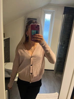 Ljusrosa kofta  - Mysig ljusrosa kofta från Selected Femme i storlek XS. Koftan har v-ringning, svarta knappar framtill och är långärmad. Materialet är mjukt och stickat, perfekt för att hålla sig varm under kyliga dagar. Enkel och stilren design som är lätt att matcha.