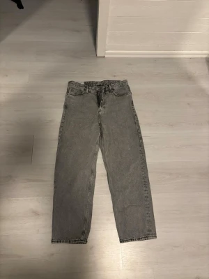 Grå loose fit jeans från H&M - Säljer ett par grå loose fit jeans från H&M i storlek 31/32. Byxorna har klassisk femficksdesign, raka ben och är tillverkade i denim. Perfekt för dig som gillar avslappnad stil och vill ha ett par snygga jeans med lite bredare passform. Knappt använda!