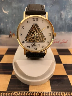 Klassisk Pierre Herman Guld Armbnadsur  - Klassisk Pierre Herman guld armbandsur med svart armband. Urtavlan har romerska siffror och ett unikt mönster i mitten. Klockan har ett fungerande quartz urverk.