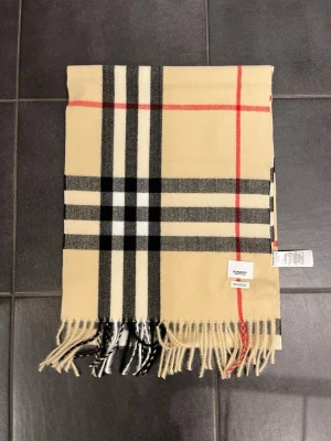 Burberry halsduk klassisk design - Burberry halsduk i beige klassisk design. Aldrig använts helt ny kan diskutera pris. Skriv gärna om ni har frågor.