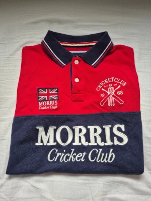 Röd Morris Cricket Club pikétröja - Snygg röd pikétröja från Morris Cricket Club pikétröja!! Den är i bra skick och har en väldigt bra passform, och har ni frågar skriv dm📌  [Nordic Resell]