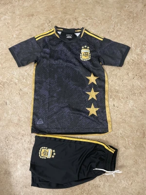 Argentina dress  - Bilderna visar ett fotbollsställ med tröja och shorts från Argentina, men inga skor finns med.