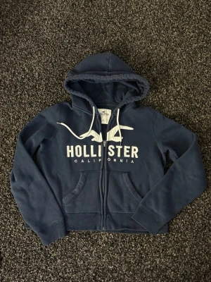 Hollister zip m=s/xs - Säljer nu denna väldigt eftertraktade hollister zip. Skick 8/10, sjukt snygg och unik. Denna blir såld fort så skynda! Obs går ner i pris vid snabb affär! 