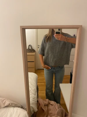 Grå stickad tröja med halvärm - Mysig grå stickad tröja med avslappnad passform och halvärmar. Tröjan har en rund halsringning och är lite loose i modellen, vilket gör den skön att bära. I storlek S💕