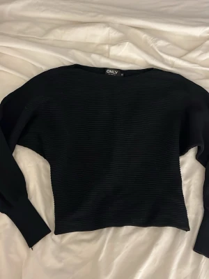 Svart ribbad tröja från ONLY - Svart långärmad tröja från ONLY med ribbad struktur och rund hals. Tröjan har en lite loose passform. Knappt använd