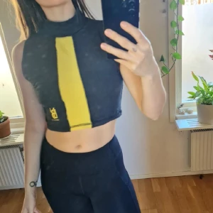 Svart croppad polotopp - Svart topp i vintage-stil med loggan VB och Venice Beach i nederkant. Mått: Längd - 37 cm. Skulle säga att den passar S-liten L 