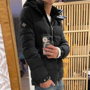 Svart pufferjacka från J.Lindeberg - Säljer nu min svarta J Lindeberg puffer i size M. Inga fläckar eller så men den har blivit lite sliten vid dragkedjan, därav priset. Sriv till mig så kan jag skicka bild på det och svarar på ev frågor. Priset kan diskuteras vid snabb affär!