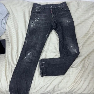 Svarta jeans från Dsquared2 (Äkta)  - Säljer ett par svarta jeans från Dsquared2 med fin design. Unika ifrån andra jeans men ändå simpelt. Modellen på de är cool guy jeans. De är autentiska och är köpta på Minto.se! Inget kvitto tyvär. Vid ytligare frågor skriv till mig.