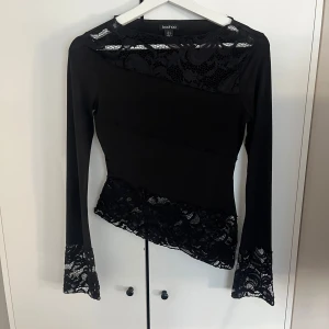 Svart långärmad topp med spets  - Svart långärmad topp från Boohoo med spetsdetaljer vid halsringning, ärmslut och nederkant. Använd en gång mycket bra skick😊